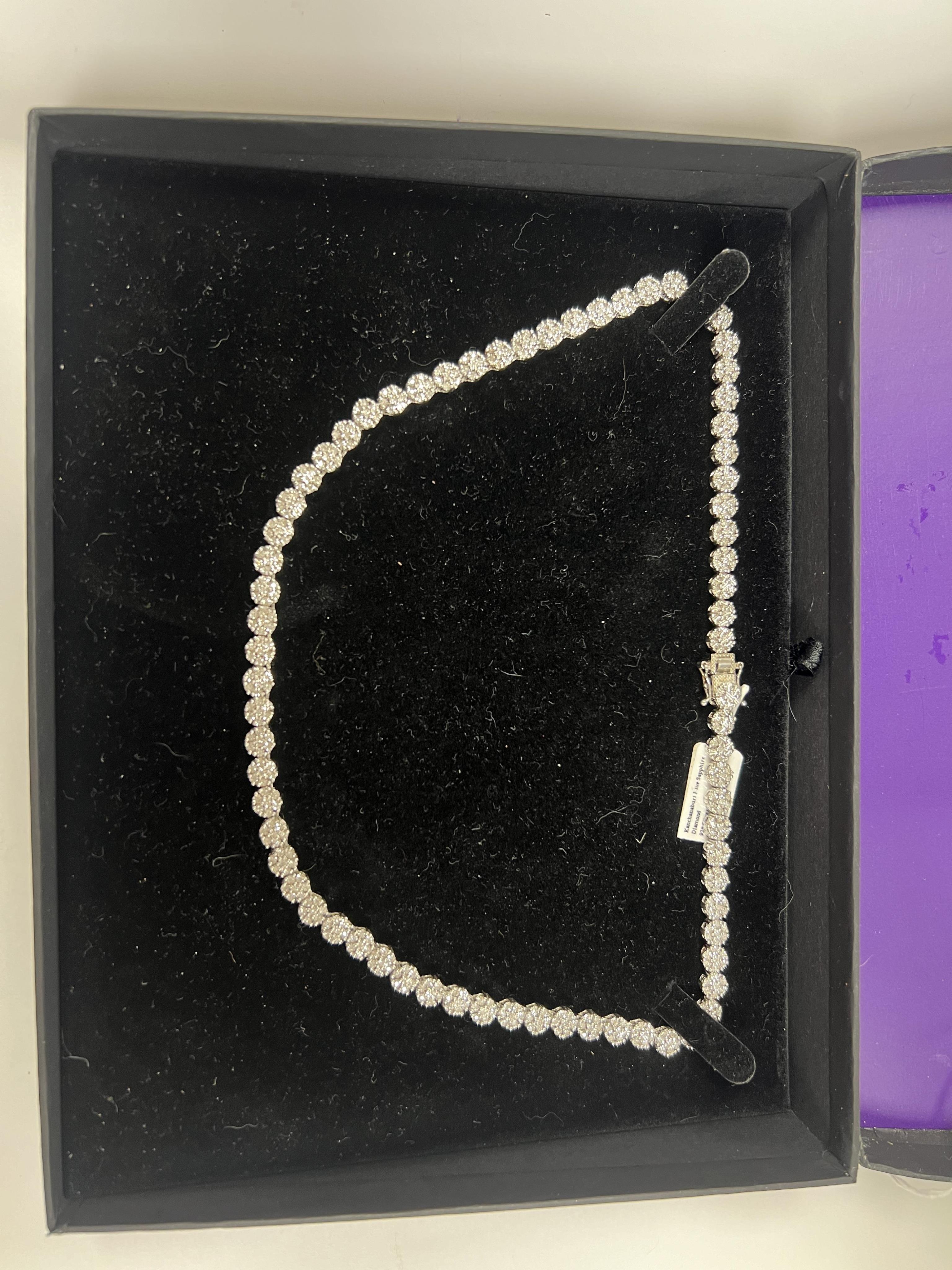 A modern Indian 925 and diamond chip set flower head cluster line necklace, 44cm, in original TJC box.